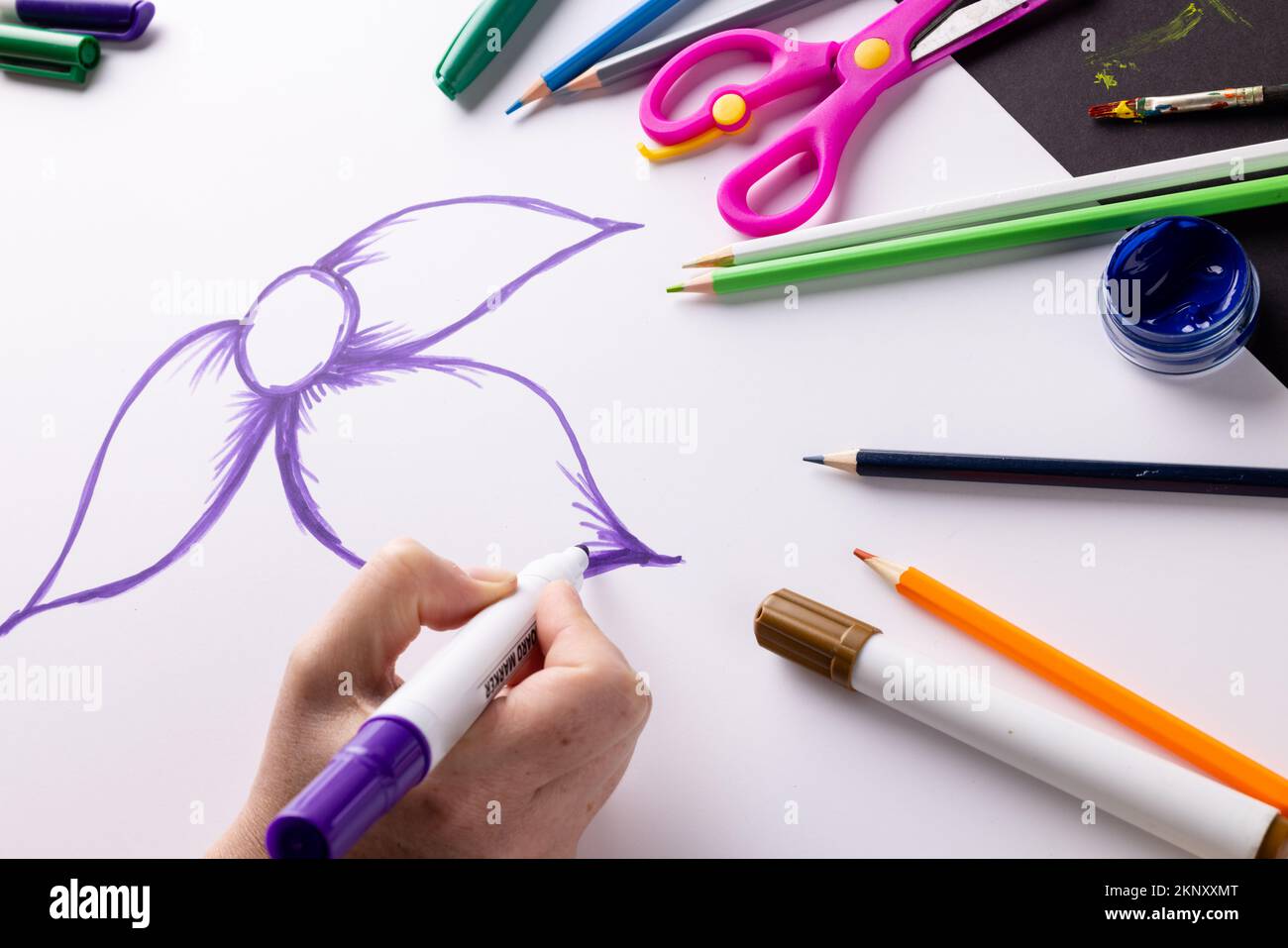 Disegno a mano di fiori viola su carta e materiali artistici sul piano del tavolo, con spazio copia Foto Stock