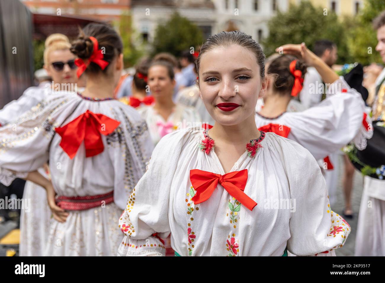 Ballerini popolari rumeni e ungheresi di fronte alla Chiesa di San Michele in Piazza Unirii, Cluj-Napoca, Romania Foto Stock