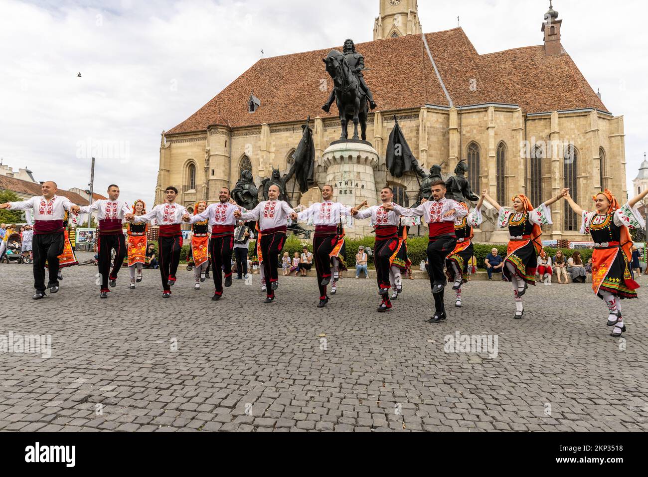 Ballerini popolari rumeni e ungheresi di fronte alla Chiesa di San Michele in Piazza Unirii, Cluj-Napoca, Romania Foto Stock