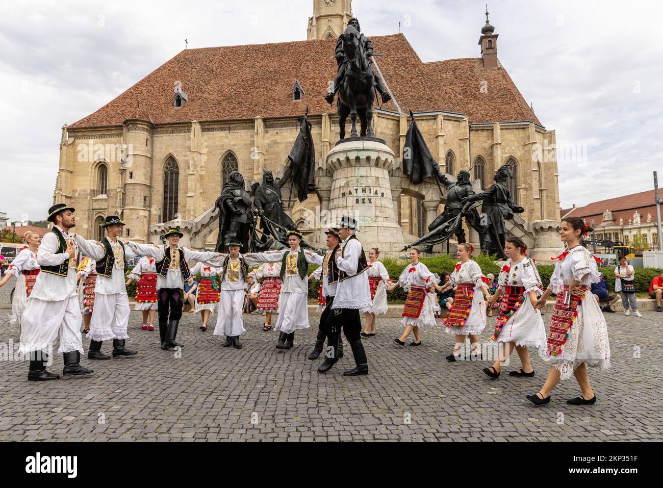 Ballerini popolari rumeni e ungheresi di fronte alla Chiesa di San Michele in Piazza Unirii, Cluj-Napoca, Romania Foto Stock