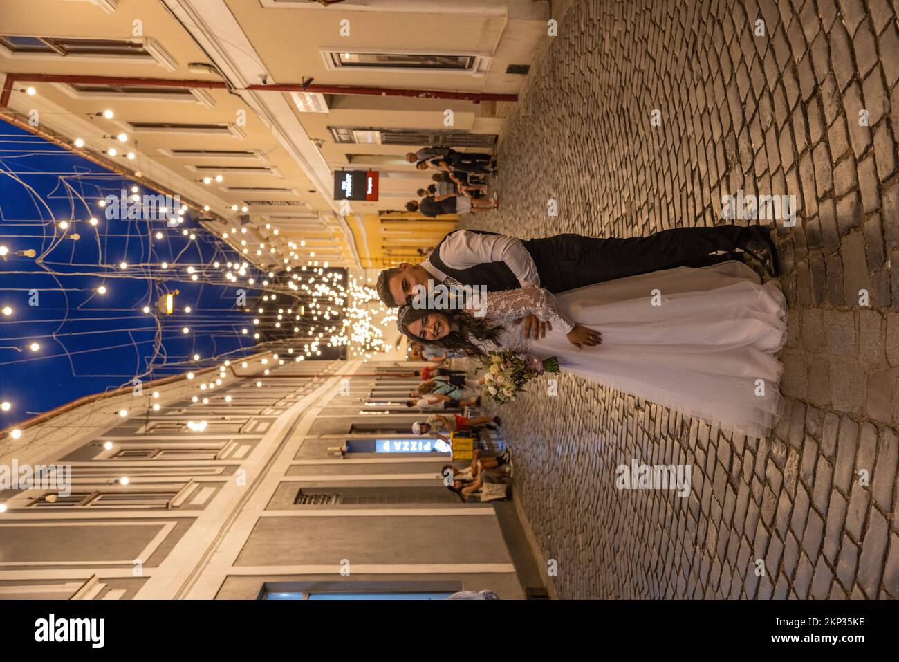 Coppia di nozze lungo le strade pedonali illuminate a Cluj-Napoca Città Vecchia, Romania Foto Stock