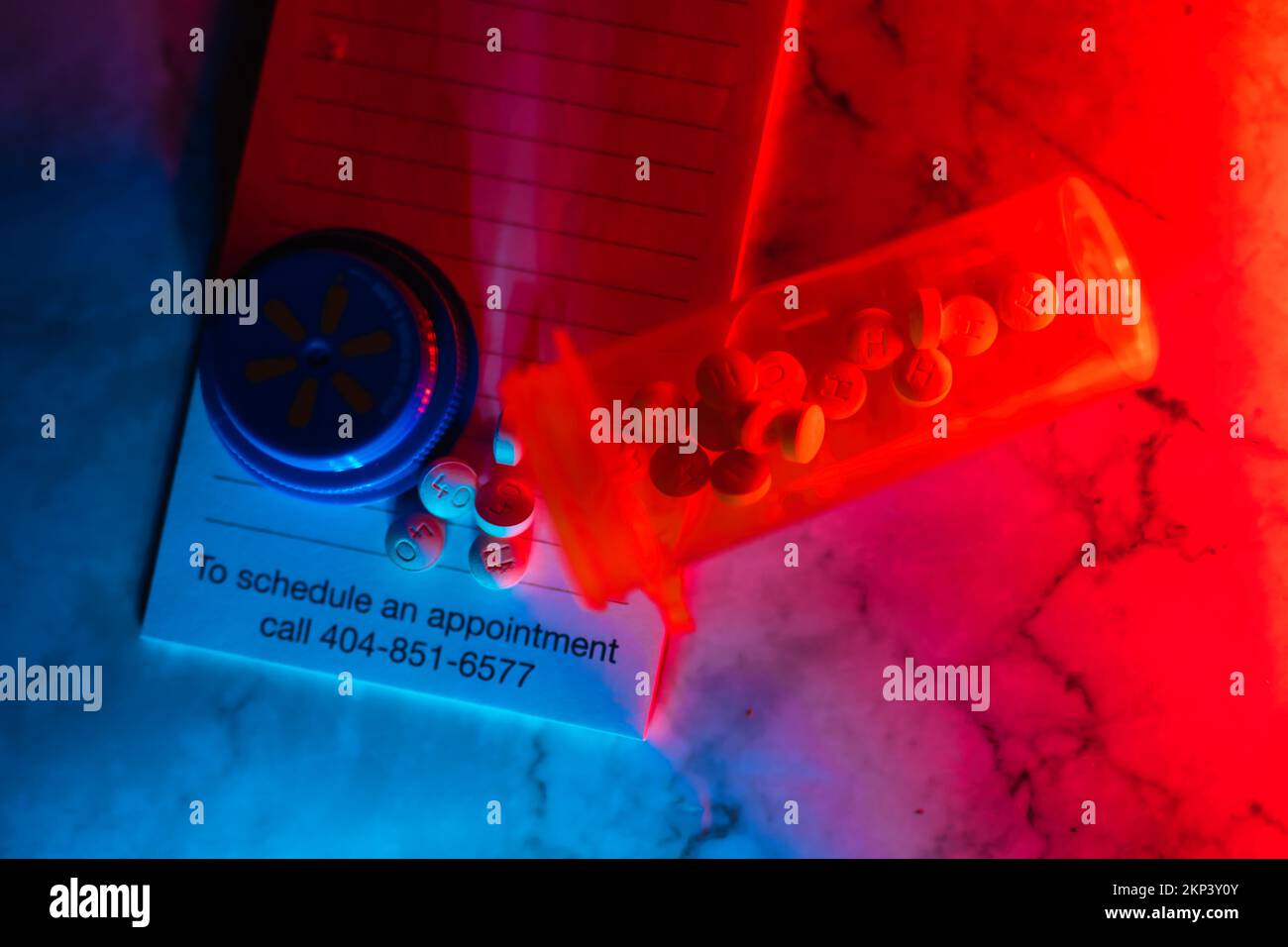 Aprire il flacone del medicinale con le pillole per qualcuno. sulla parte superiore di un tastierino di prescrizione luci a led al neon Foto Stock