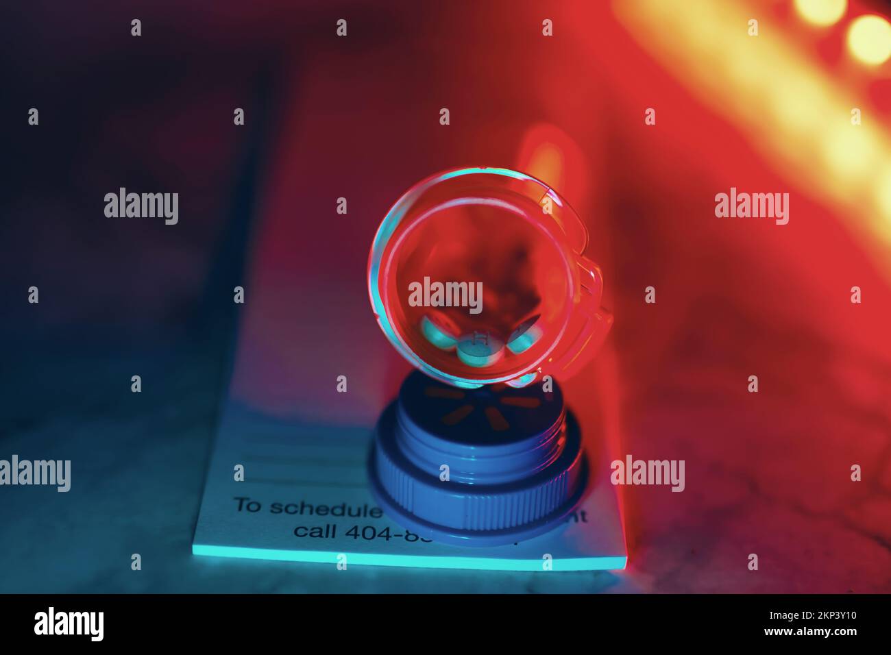Aprire il flacone del medicinale con le pillole per qualcuno. sulla parte superiore di un tastierino di prescrizione luci a led al neon Foto Stock