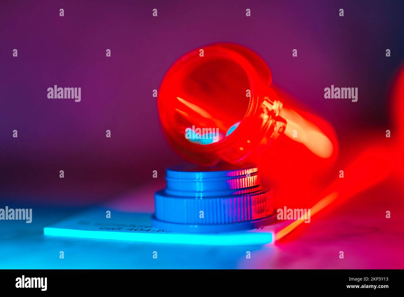 Aprire il flacone del medicinale con le pillole per qualcuno. sulla parte superiore di un tastierino di prescrizione luci a led al neon Foto Stock