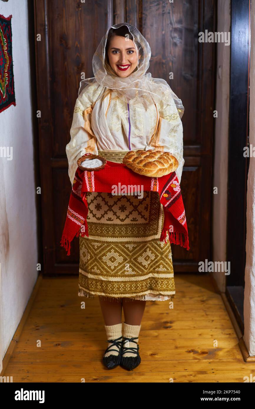 Giovane donna rumena in costume tradizionale sposa popolare che offre pane e sale come benvenuto Foto Stock