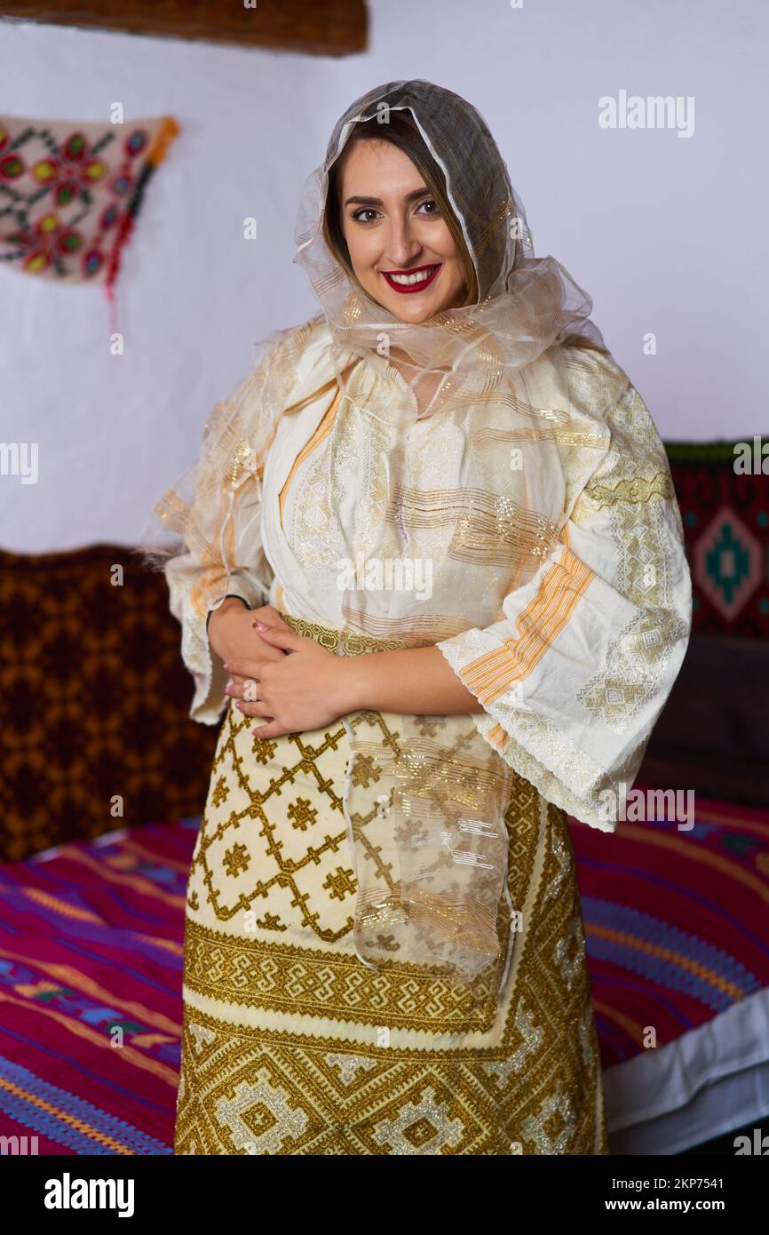 Giovane donna rumena in costume tradizionale sposa popolare in una casa d'epoca Foto Stock