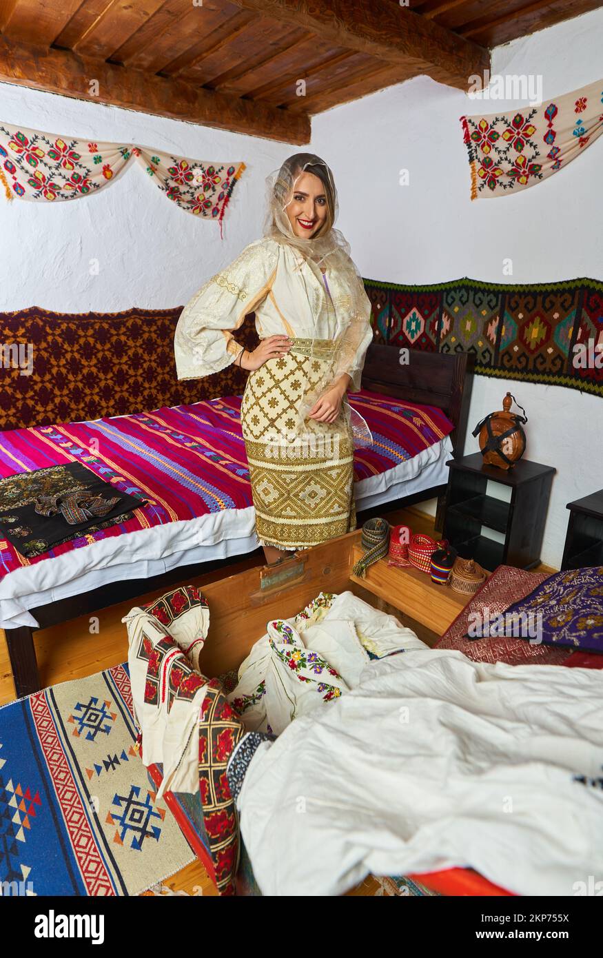Giovane donna rumena in costume tradizionale sposa popolare in una casa d'epoca Foto Stock