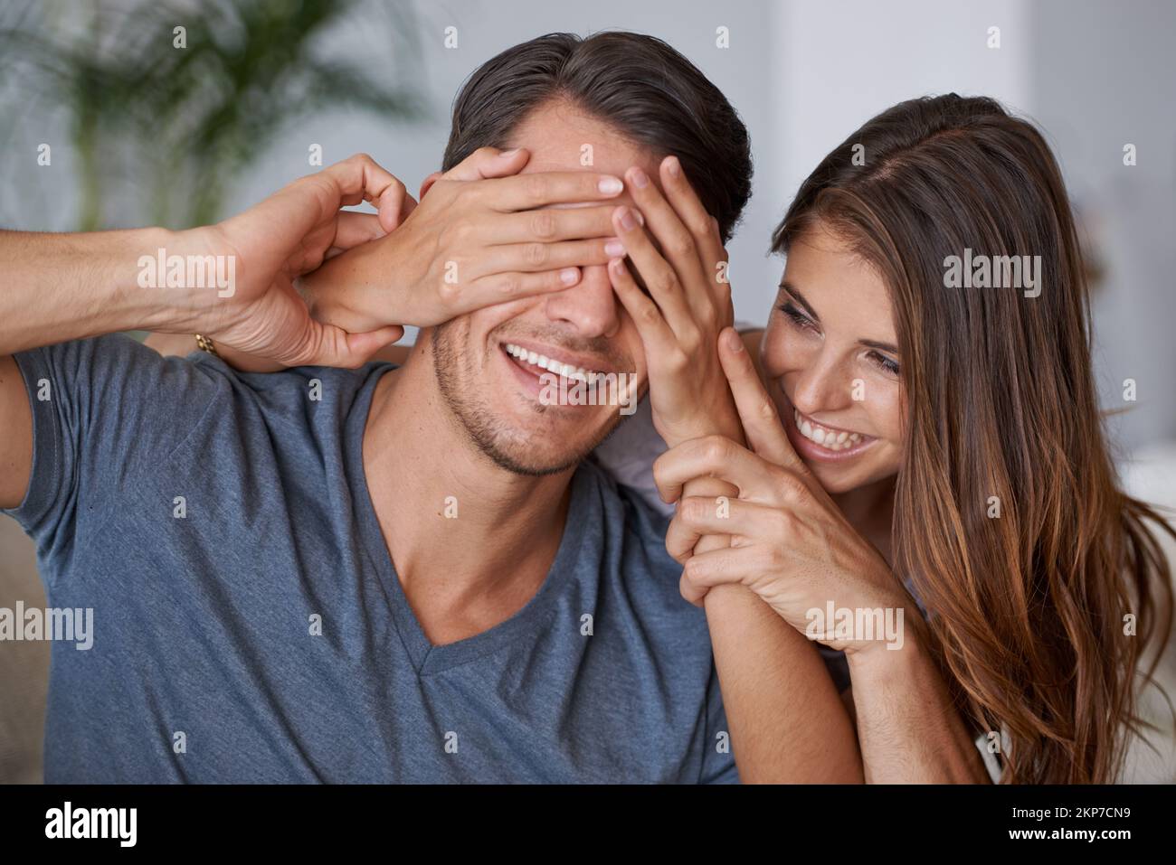 Indovina quello che ti ho ottenuto. una giovane donna che copre gli occhi dei mariti per una sorpresa. Foto Stock