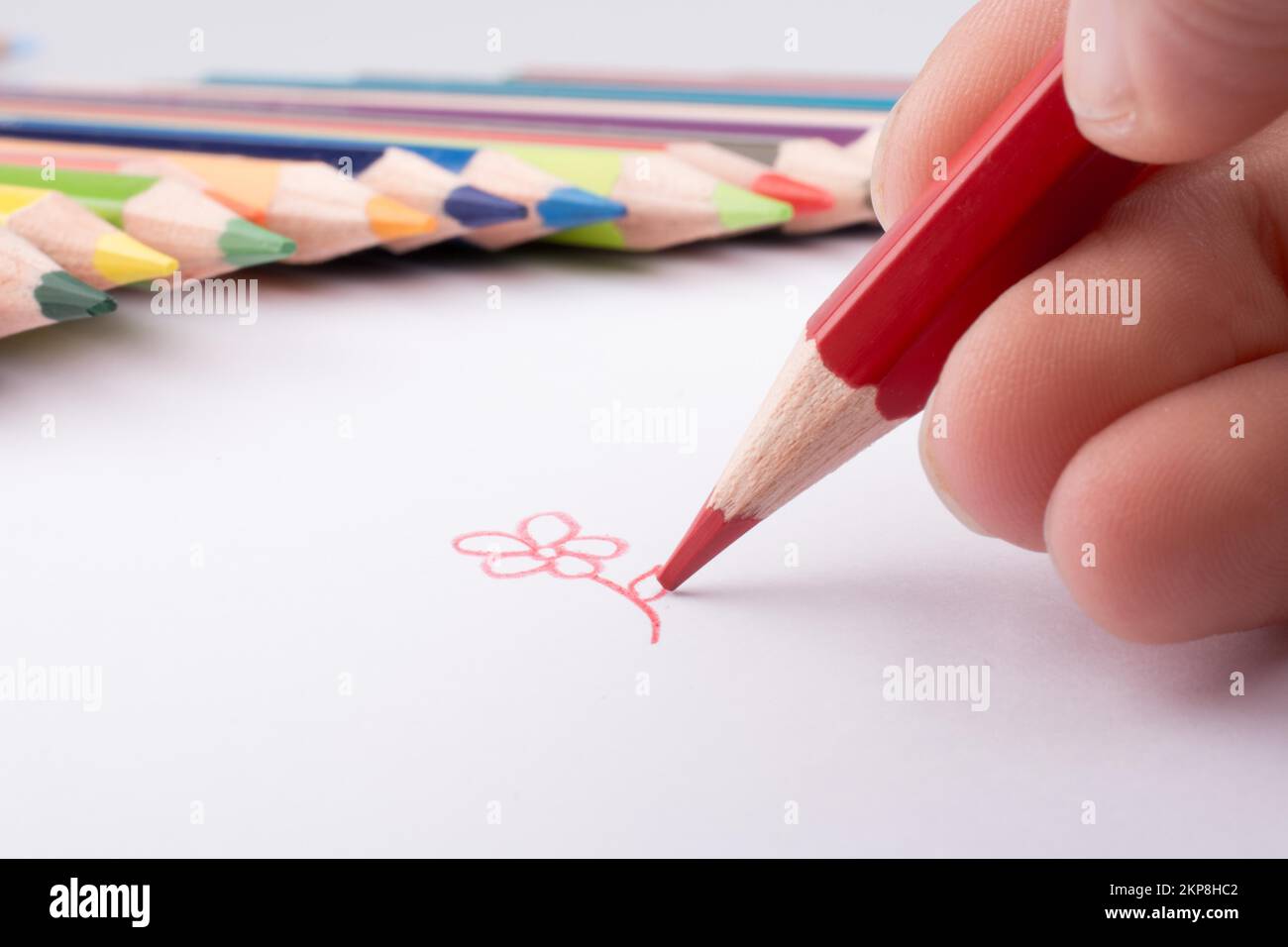 Disegno a mano nei pressi di matite a colori su sfondo bianco Foto Stock