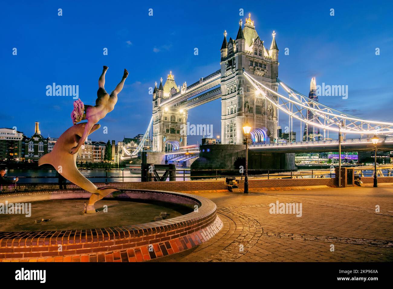 Ragazza di scultura con delfino di fronte al Tower Bridge sul Tamigi al tramonto, Londra, City of London, Inghilterra, Regno Unito, Gran Bretagna, Europa Foto Stock