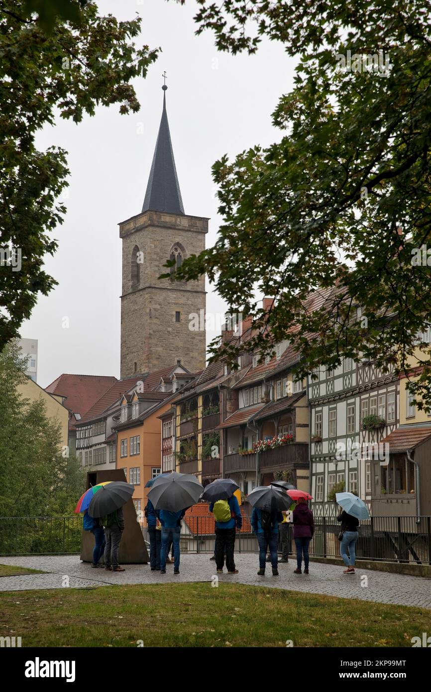 Gruppo di persone sotto la pioggia davanti alle case a graticcio del Krämerbrücke e delle Aegidienkirche, Erfurt, Turingia, Germania, Europa Foto Stock