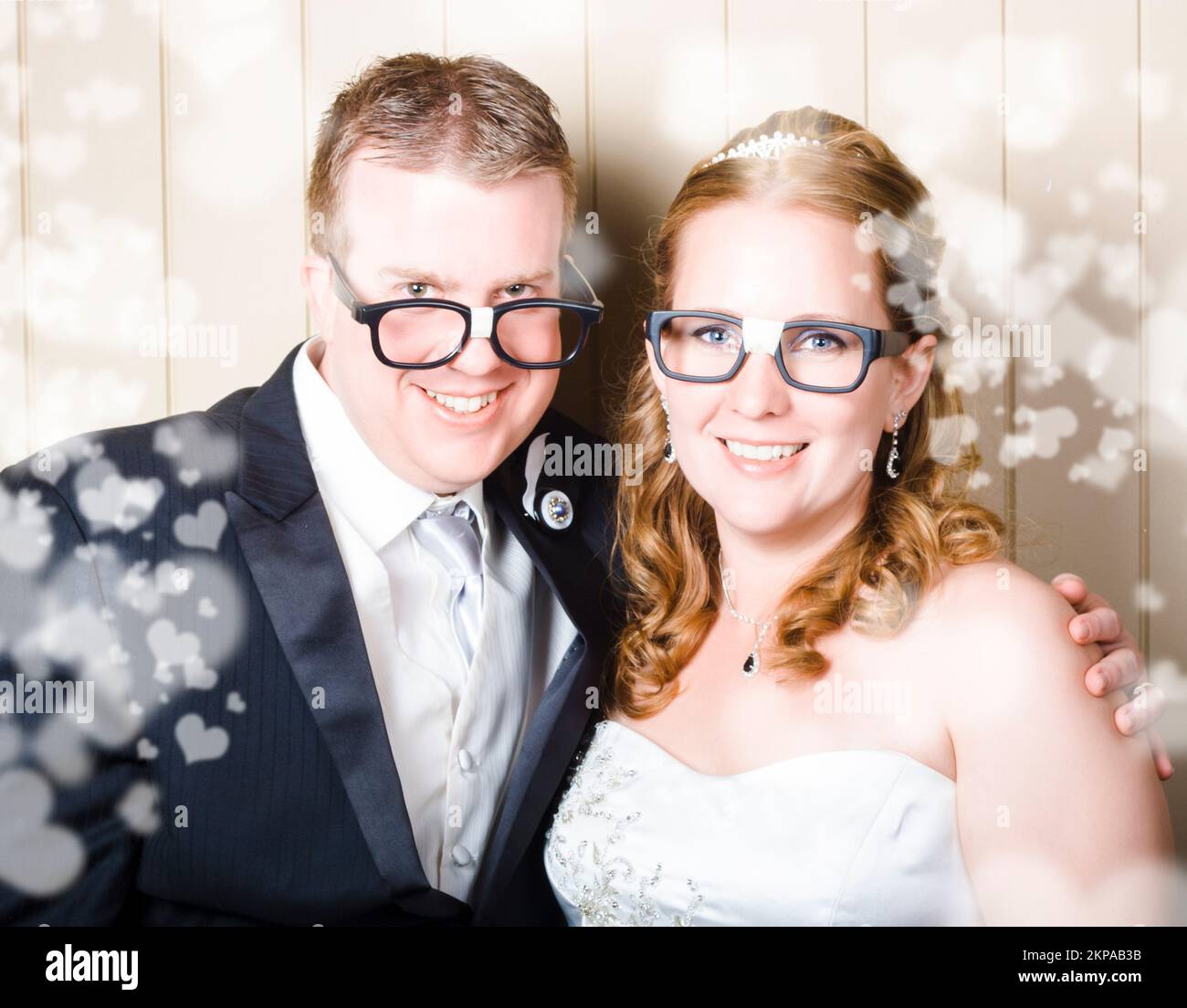 Umoroso sposa e sposo in occhiali da geek stereotipati che celebrano un'occasione di nozze intelligente con amore a forma di cuore Foto Stock