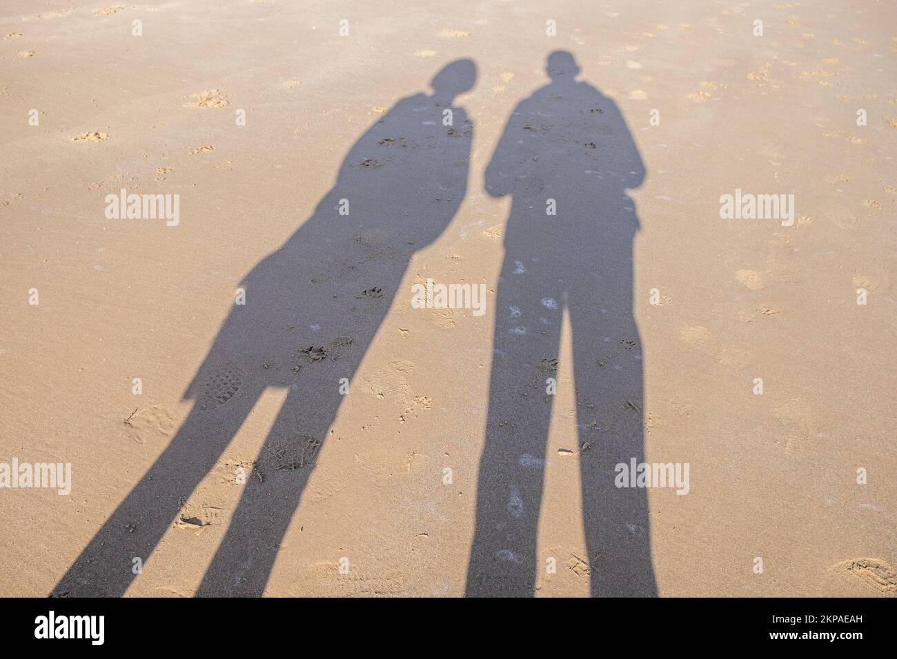 Un'ombra di due persone su una spiaggia. Foto Stock