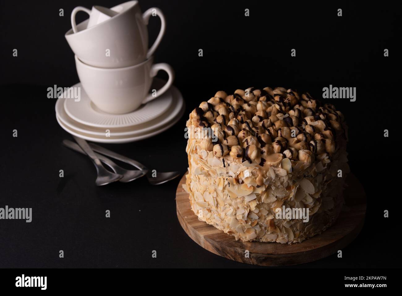 foto torta rotonda con piatti cucchiai piattini impilati in una fila verticale Foto Stock