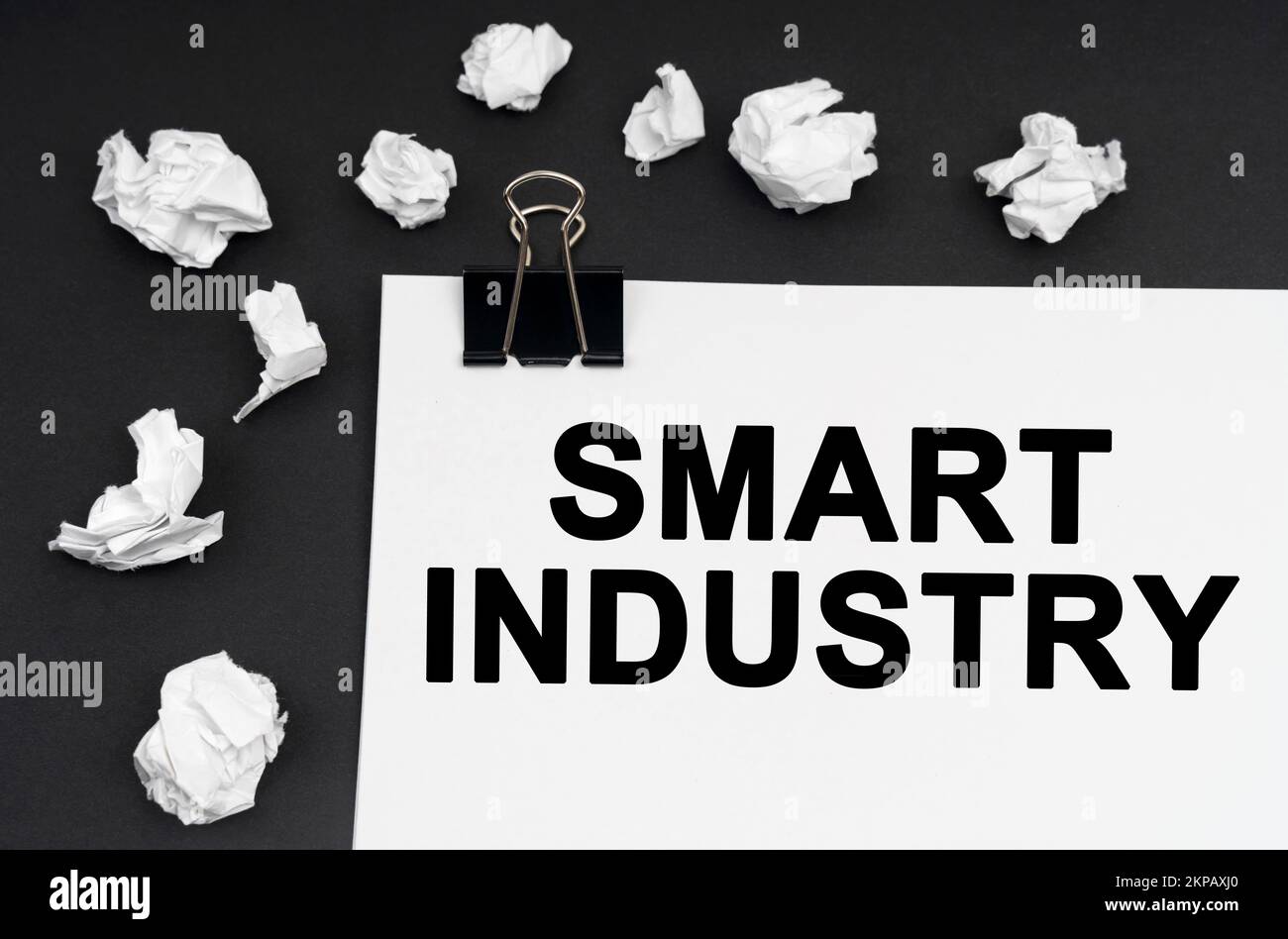 Concetto industriale. Su uno sfondo nero, ci sono pezzi di carta e carta stropicciati con l'iscrizione - Smart Industry Foto Stock