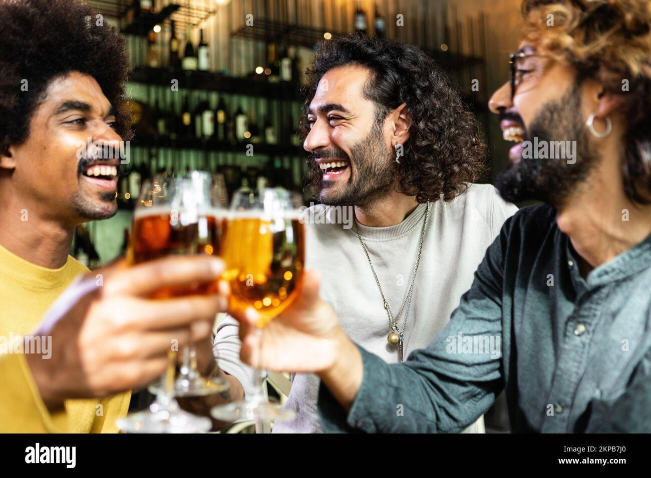 Felici amici multirazziali bere birra al bar pub Foto Stock