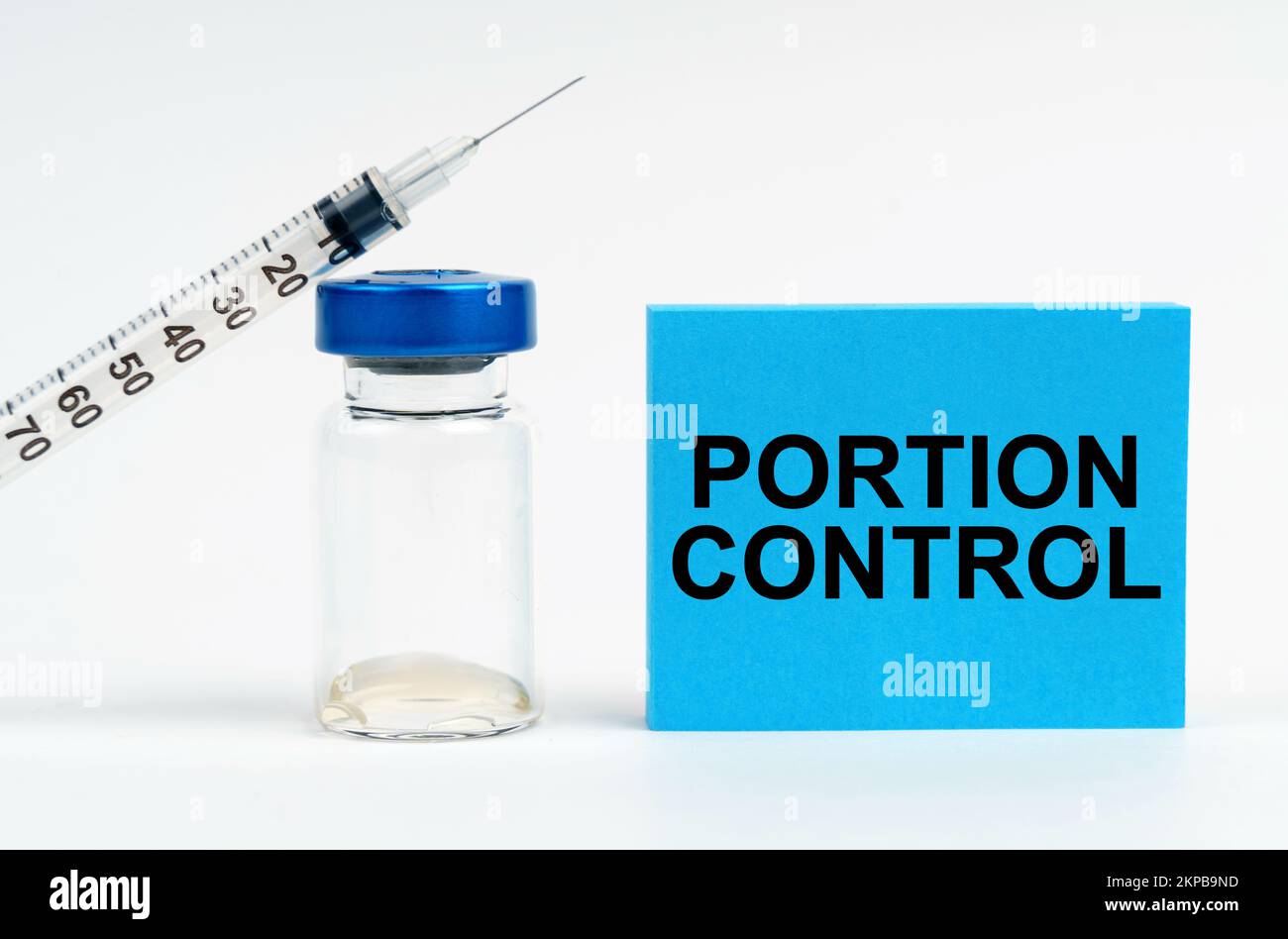 Concetto di medicina. Sul tavolo sono presenti una siringa, un'iniezione e un segno blu con l'iscrizione - controllo della porzione Foto Stock