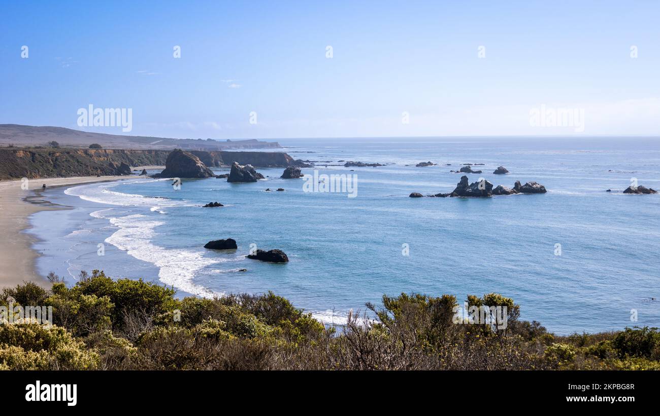 La splendida costa occidentale della California lungo l'autostrada 1, con prati e rocce, un cielo blu e un mare Foto Stock
