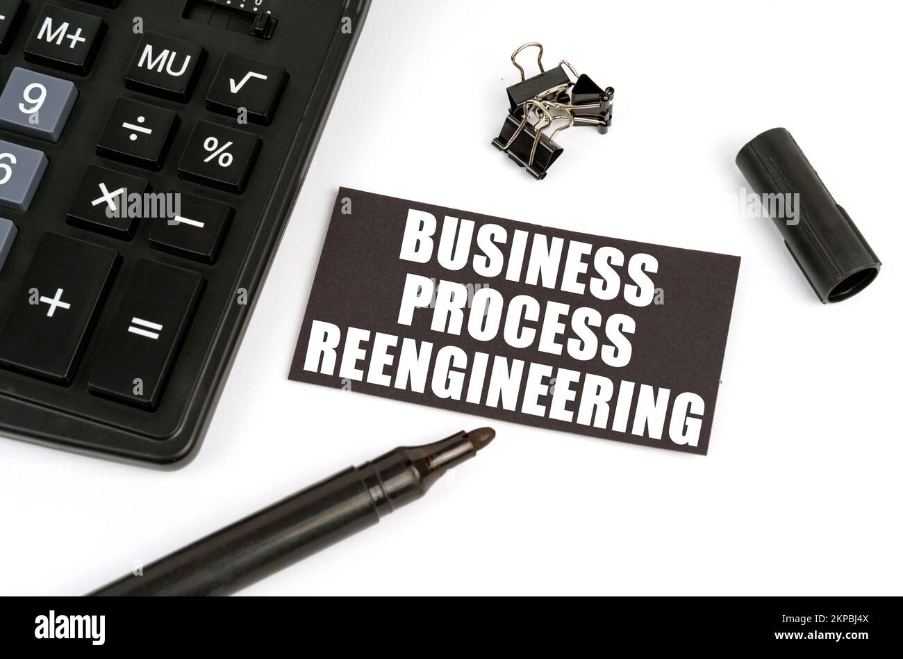 Concetto di business e finanza. Su una tabella bianca c'è una calcolatrice, un marcatore e una targa nera con l'iscrizione - Business Process Reengineering Foto Stock