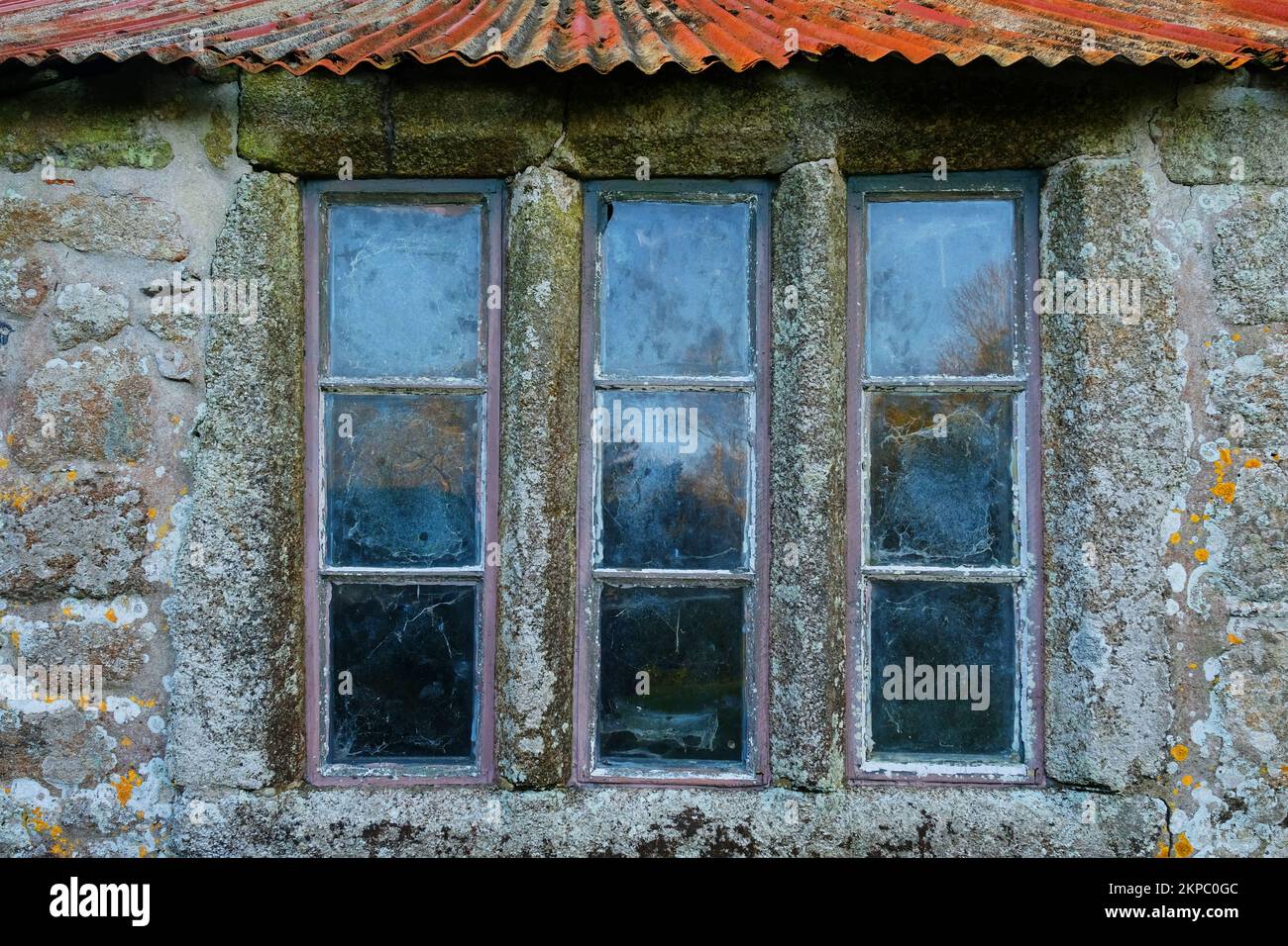 Una vecchia finestra biblionata resettato all'interno di una parete di granito, Cornovaglia, Regno Unito - John Gollop Foto Stock