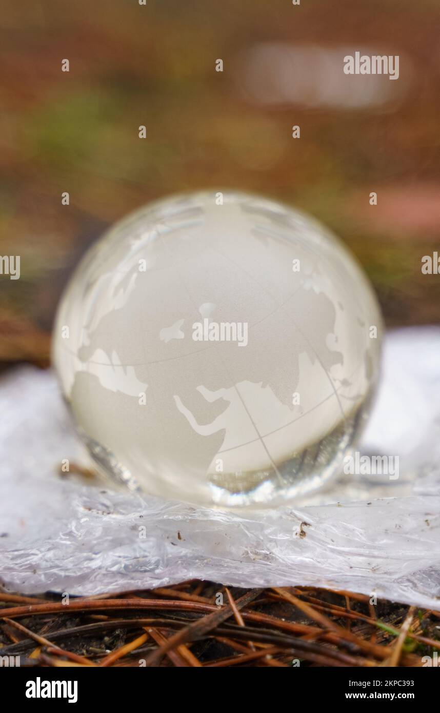 Concetto di ecologia e protezione ambientale. Il sacchetto in polietilene è dotato di un globo di vetro. Salvare il pianeta Foto Stock