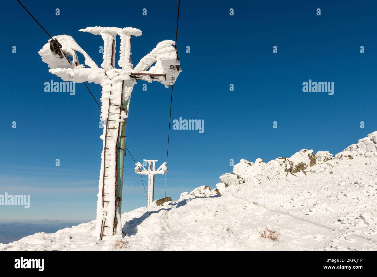 Vecchi piloni di seggiovia arrugginiti in disuso ricoperti di neve e ghiaccio sul monte Vitosha sopra Sofia, Bulgaria, con il sole e con spazio fotocopie Foto Stock