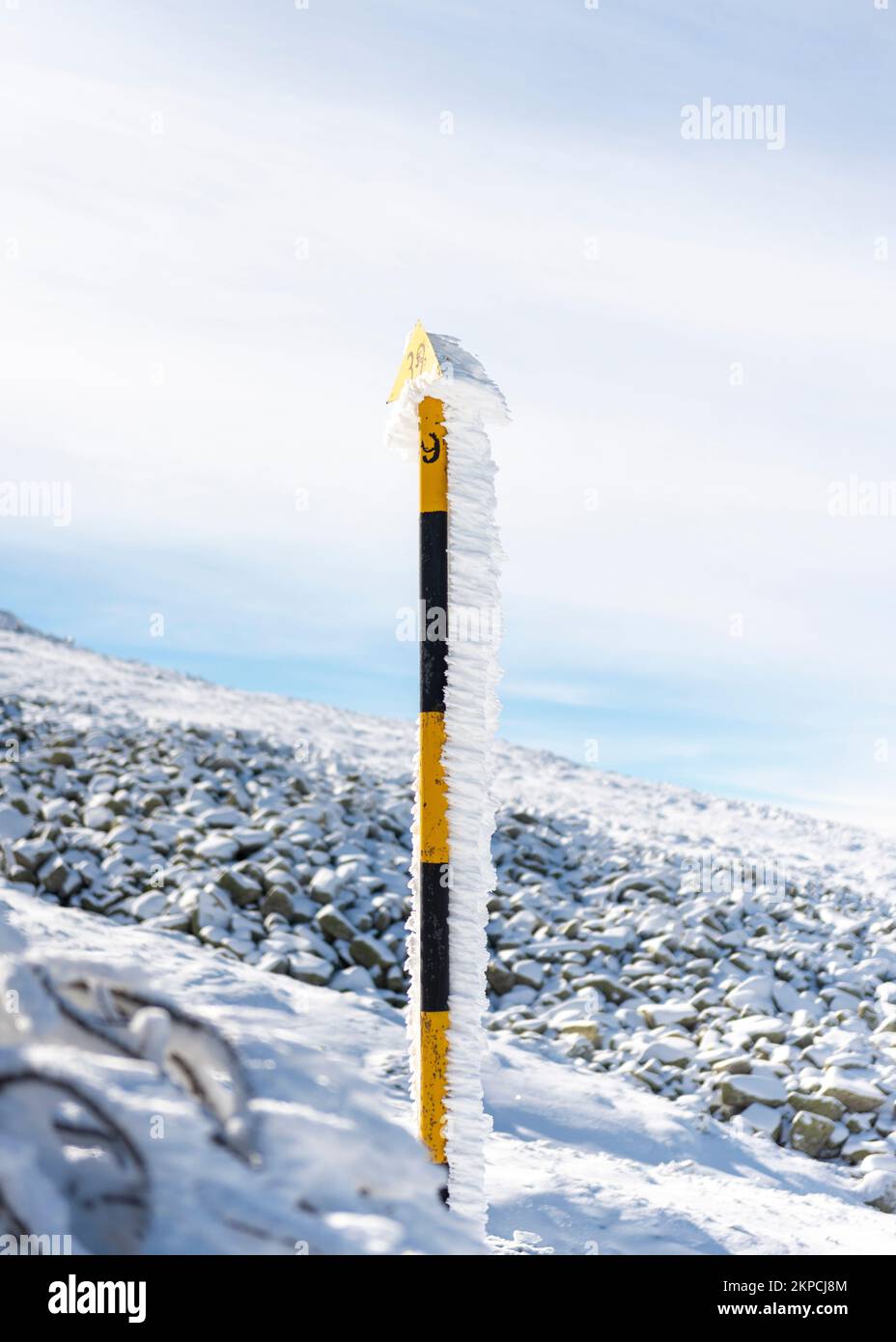 Pennarello per palo con livello di neve ghiacciato in condizioni di vento. Foto Stock