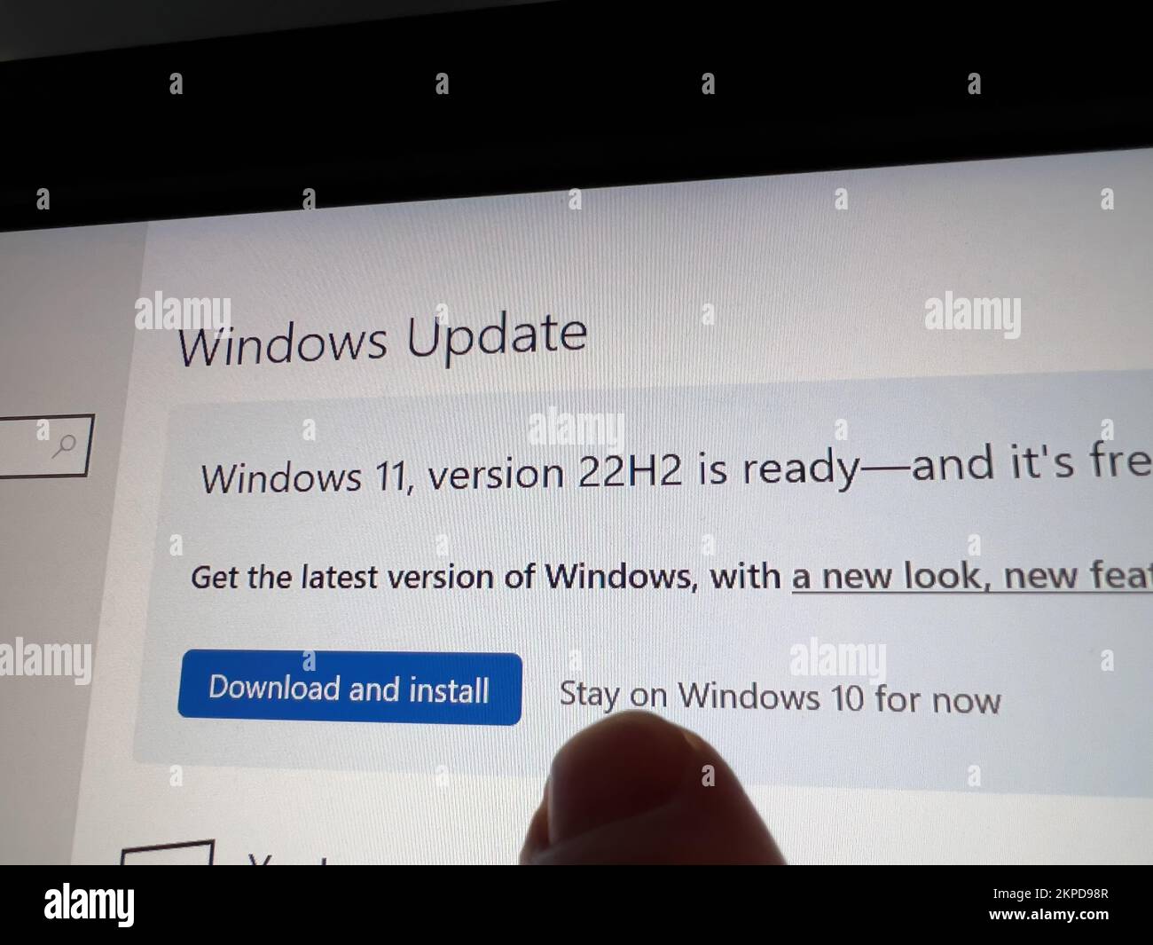 Parigi, Francia - 5 ottobre 2022: POV dito maschio che mostra al touch-screen di un display - Windows Update Windows 11 versione 22h2 è pronto per essere scaricato - installare o rimanere su Windows 10 ora Foto Stock