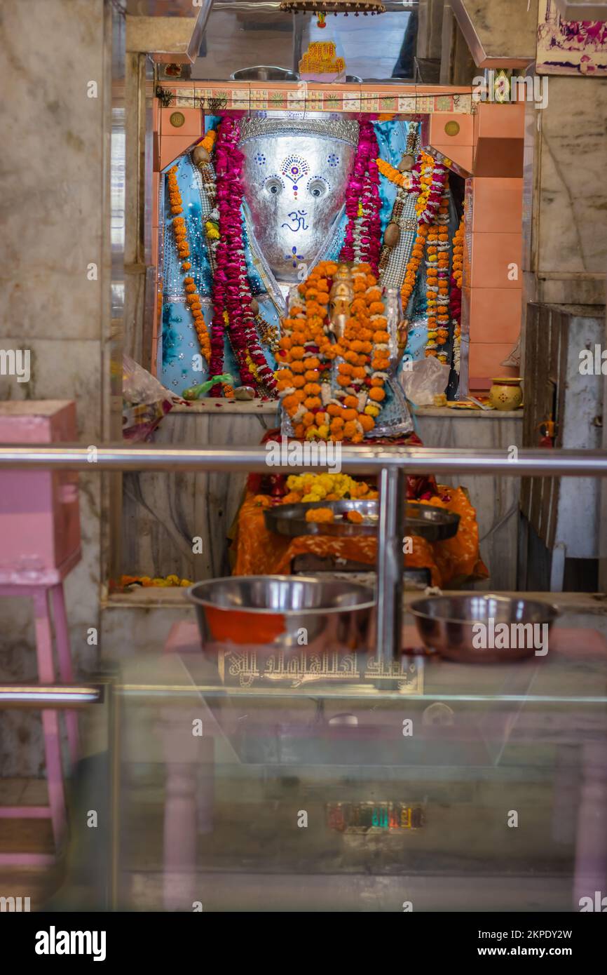 indù dio ganesha idolo adorato con fiori verticale sparato da immagine piatta angolo è presa a tempio di ganesh ratanada jodhpur rajasthan india. Foto Stock