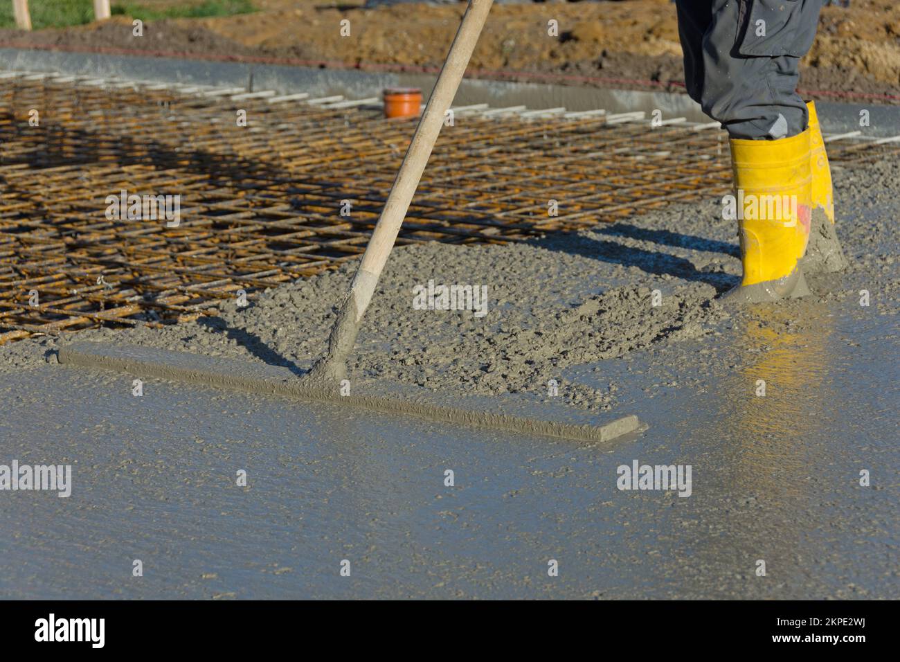 Il lavoratore di costruzione leviga calcestruzzo di una soletta di pavimento Foto Stock