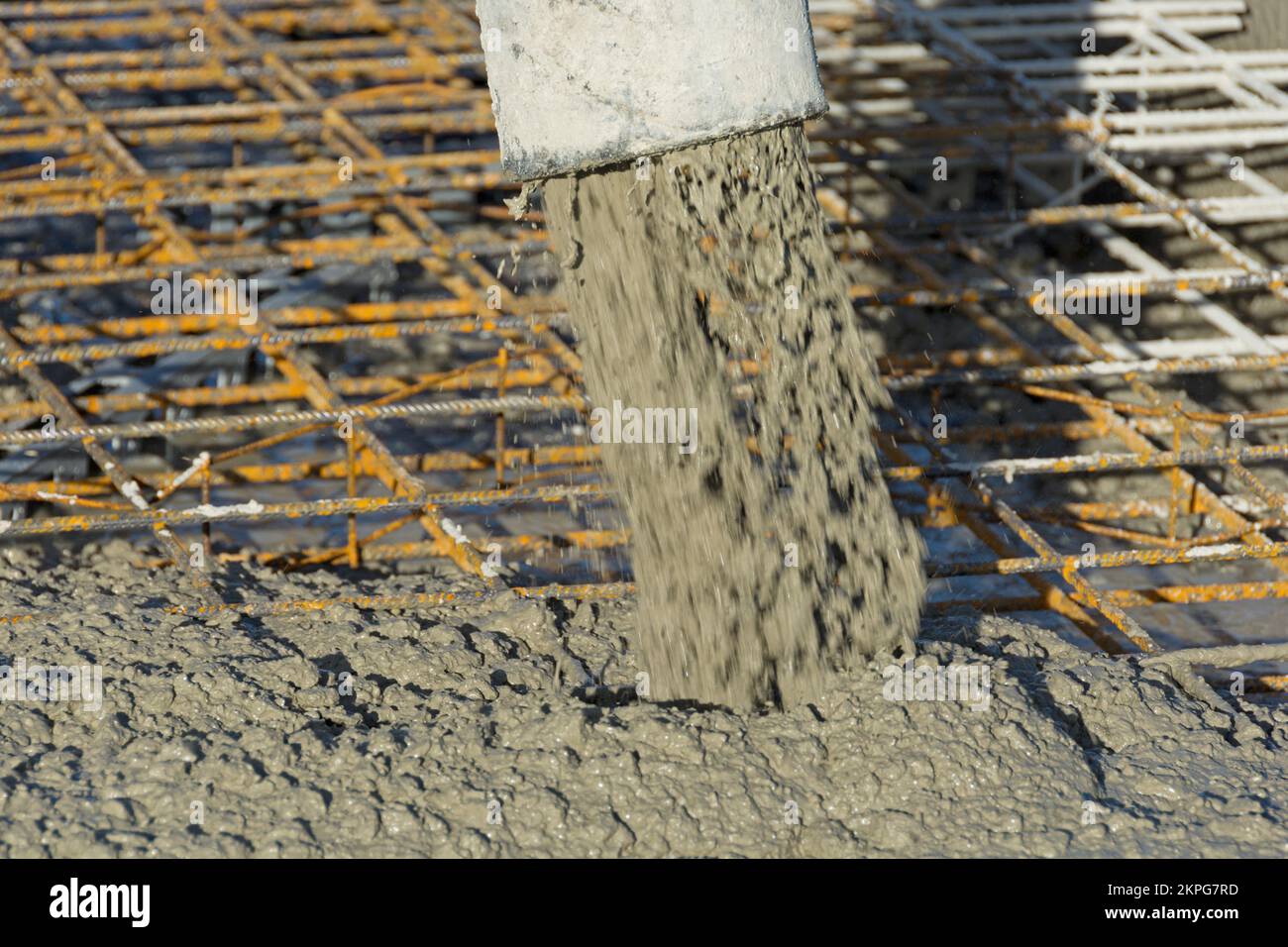 La pompa per calcestruzzo pompa il calcestruzzo sul rinforzo in acciaio Foto Stock