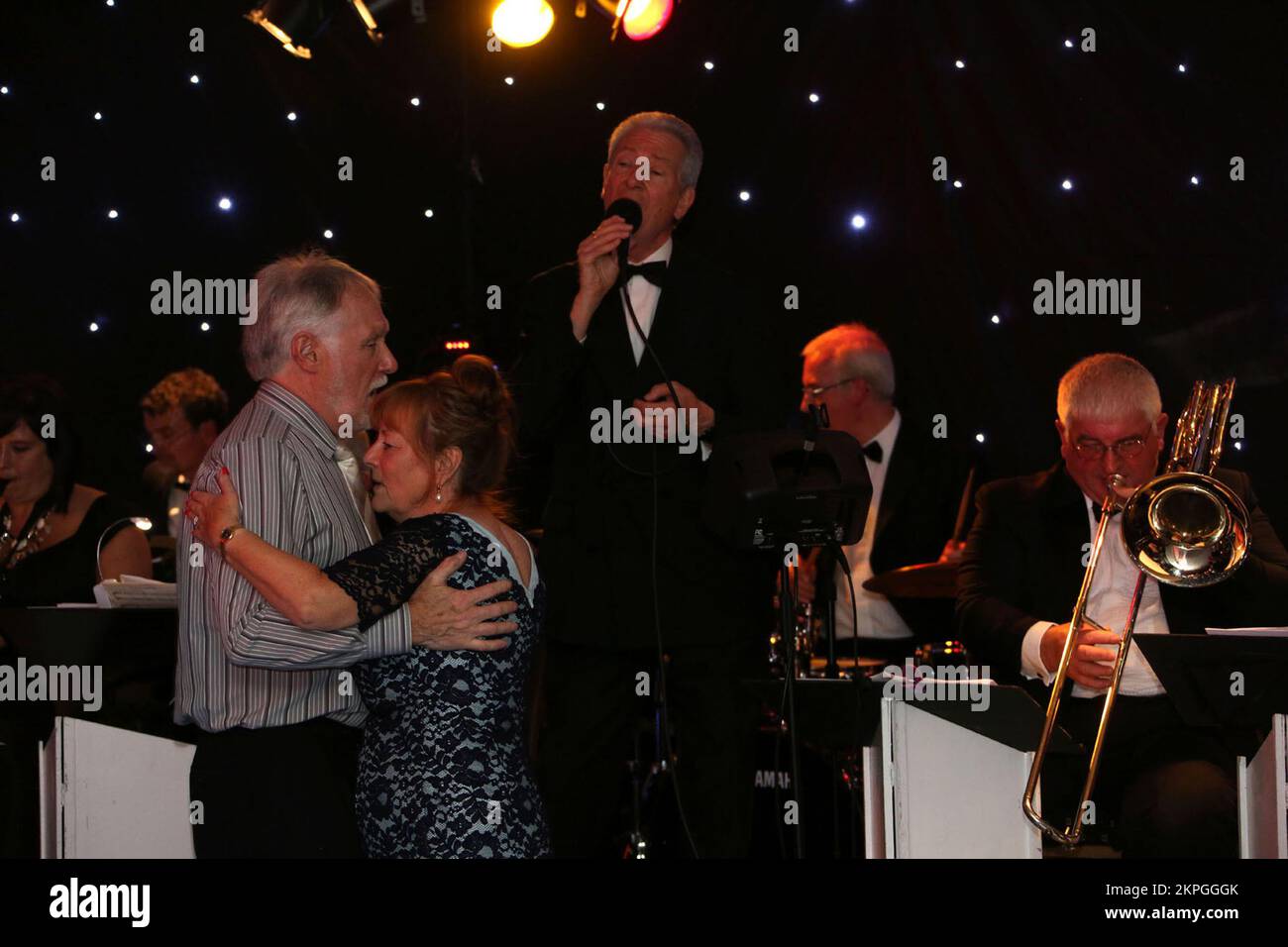 Carlton Hotel, Prestwick, Ayrshire, Scozia, Regno Unito . Due persone anziane ballano di fronte a una cantante a una band musicale di grande livello in un'occasione di beneficenza per una cena di raccolta Foto Stock