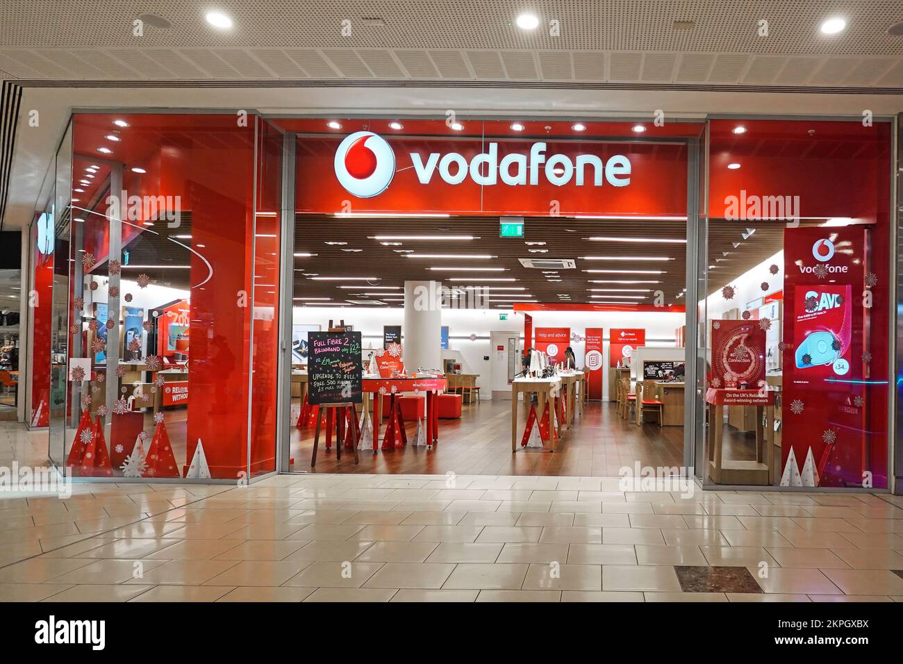 Logo Vodafone Red Shop Frontage e cartello con marchio con vista interna dei banchi di vendita al coperto all'interno del centro commerciale Lakeside West Thurrock Essex Inghilterra UK Foto Stock