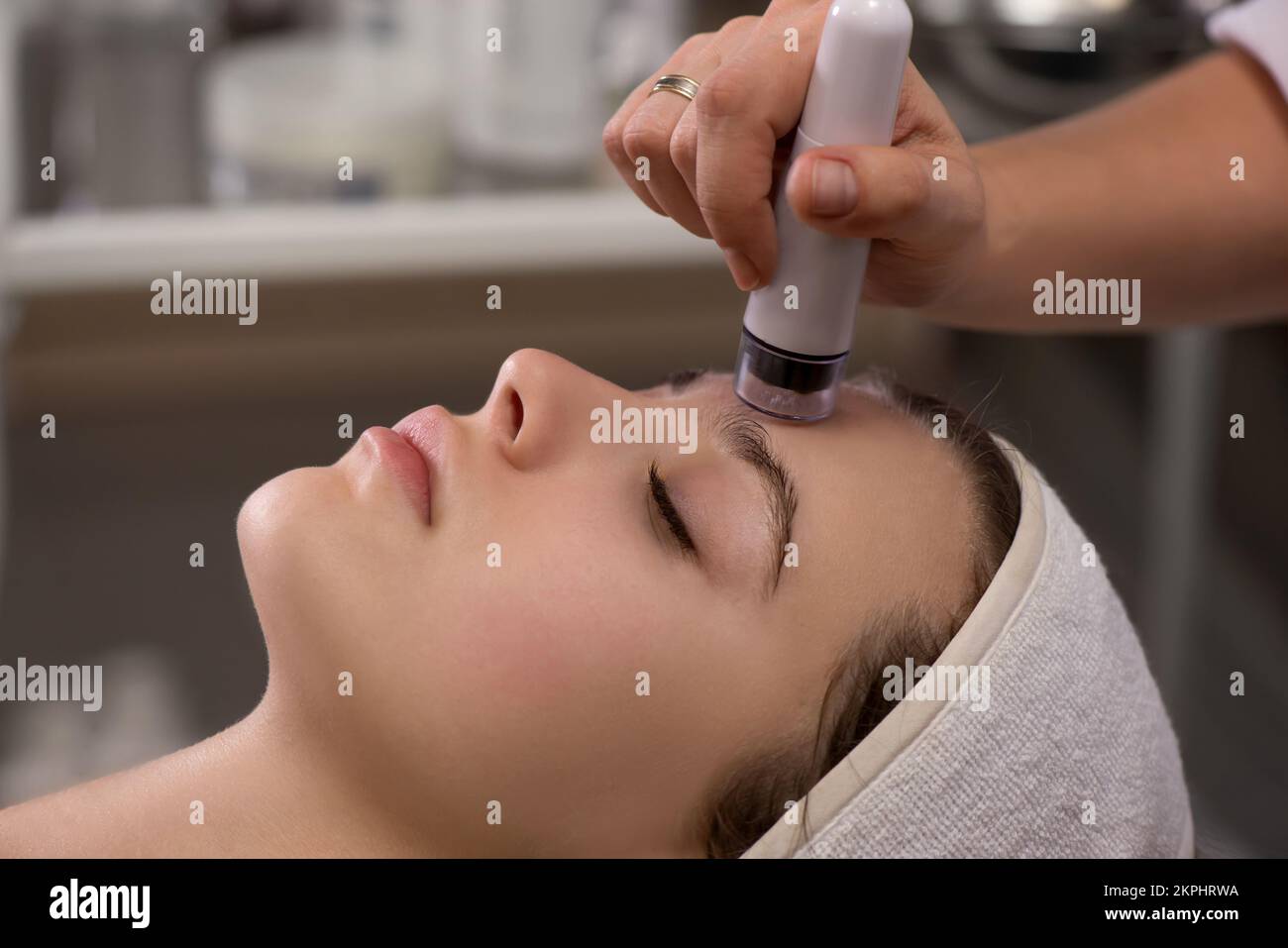 Trattamento viso ringiovanente, isolato su bianco. Modello ottenere massaggio lifting terapia in un salone di bellezza SPA. Esfoliazione, ringiovanimento Foto Stock