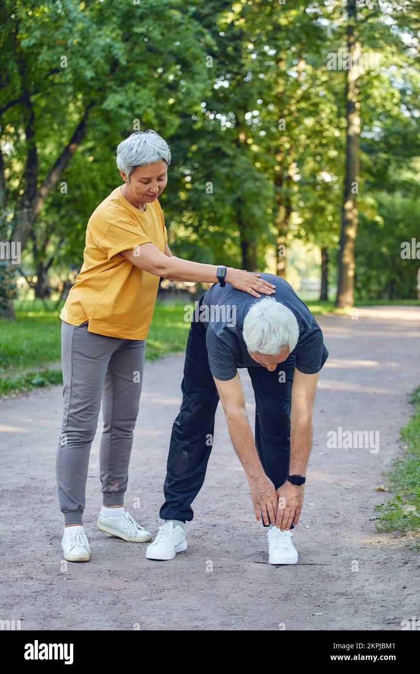 Coppia anziana sposata che lavora fuori, facendo le esercitazioni all'aperto. Stile di vita sportivo sano o pensionamento concetto Foto Stock