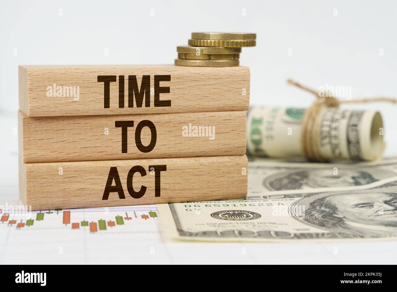 Concetto di business e finanza. Sul tavolo sono dollari, carte finanziarie e tavole di legno su cui è scritto - TEMPO DI AGIRE Foto Stock