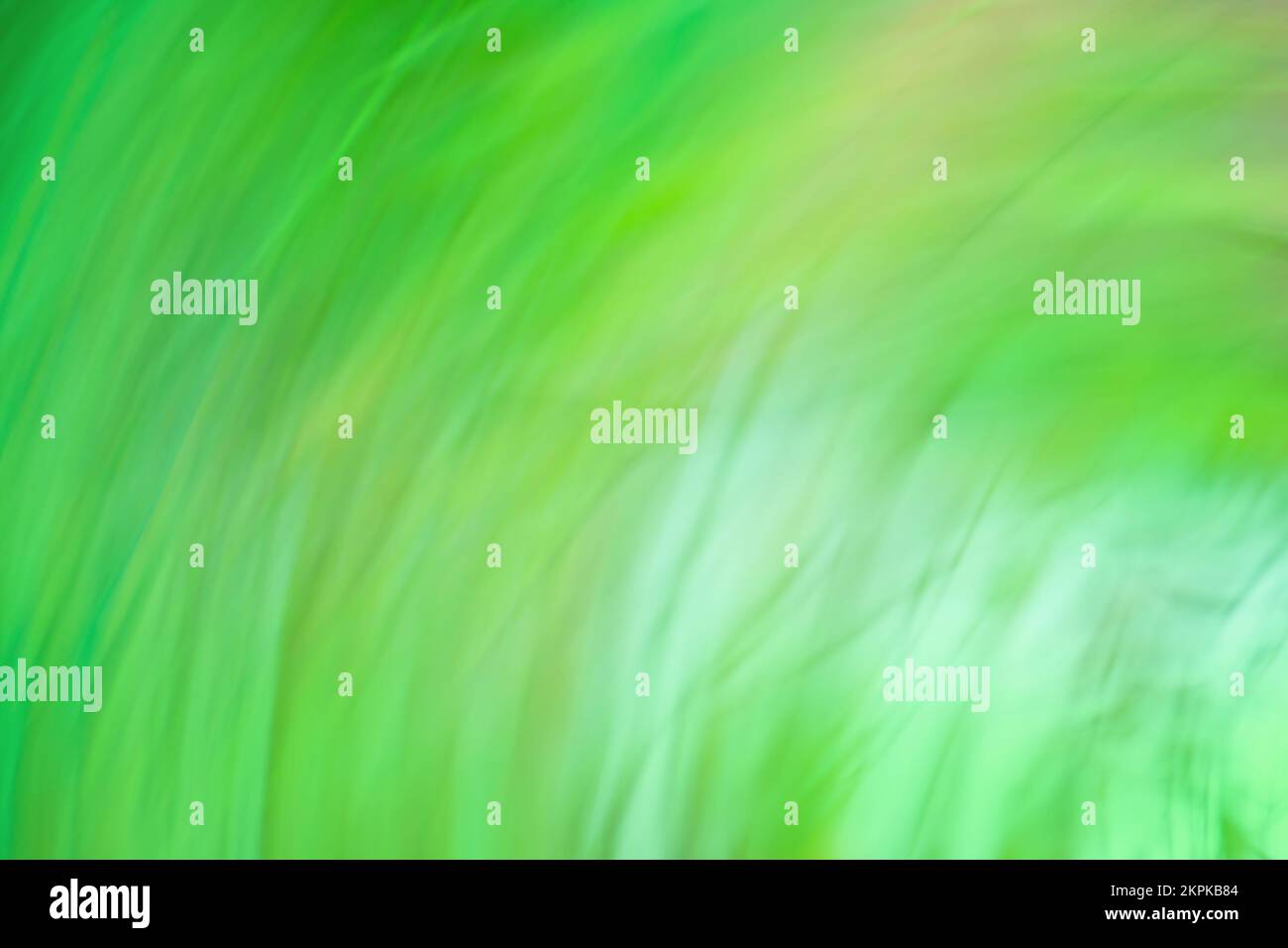 Le luci si muovono in un pattern circolare verde. Bokeh radiale di movimento per sfondo verde di Natale. Foto Stock