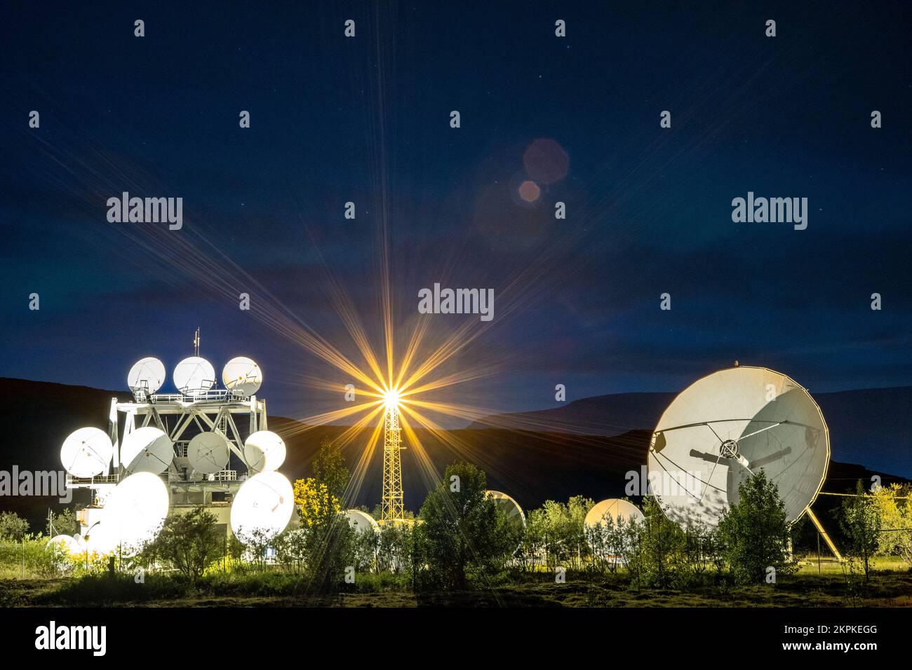 Una schiera di parabole satellitari sotto il cielo notturno Foto Stock