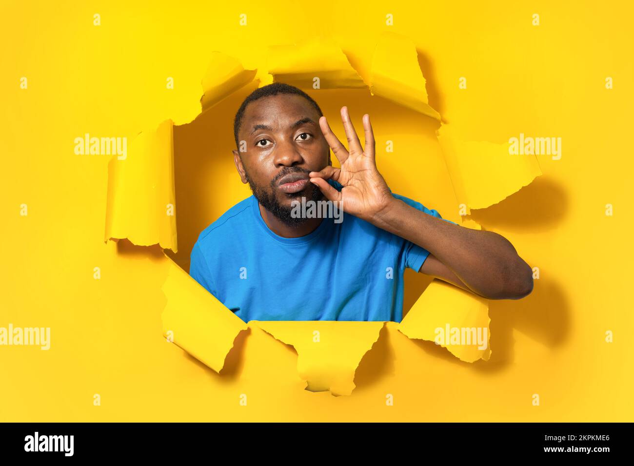 Le mie labbra sono sigillate con promessa. Serio uomo afroamericano tenere la bocca chiusa, facendo zip gesto, rimanere in silenzio Foto Stock