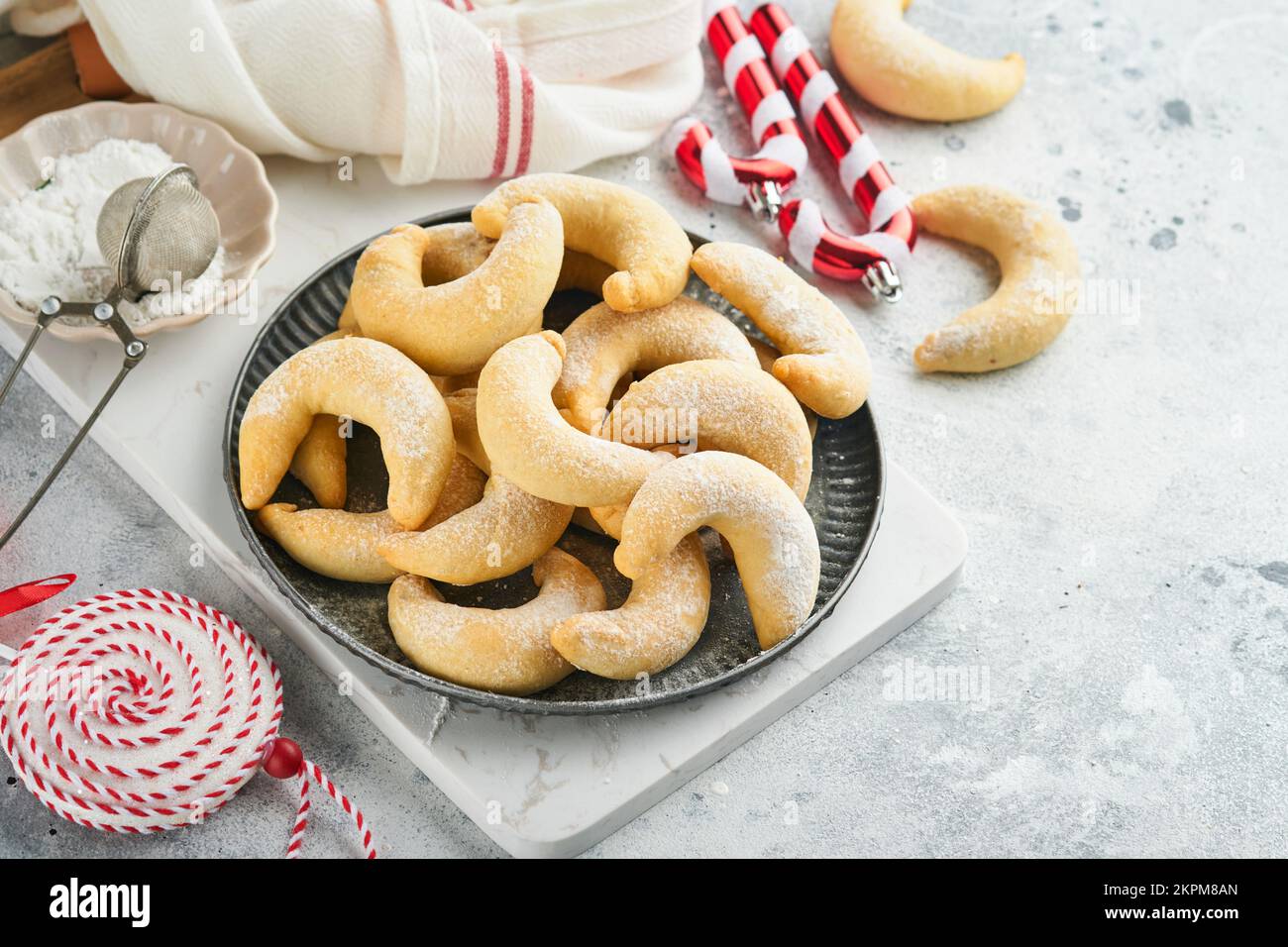 Biscotti di Natale crescents. Biscotti tradizionali di Natale fatti in casa cressenze di vaniglia in piatto rustico con decorazioni natalizie sul vecchio backgroun grigio Foto Stock