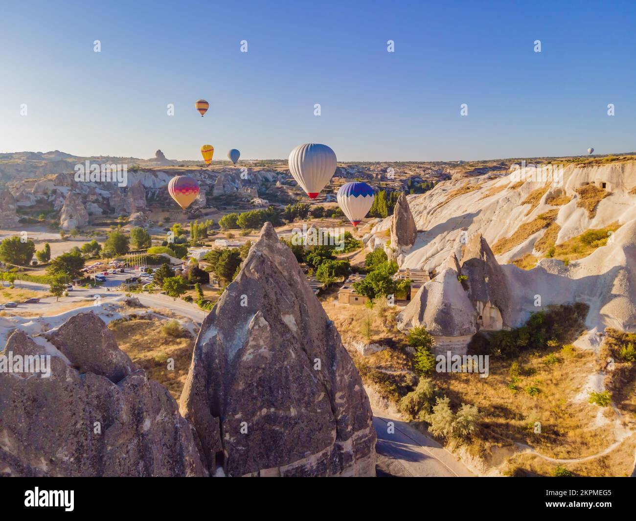 Coloratissime mongolfiere che volano nella valle dei camini delle fate a Nevsehir, Goreme, Cappadocia Turchia. Spettacolare vista panoramica del drone Foto Stock
