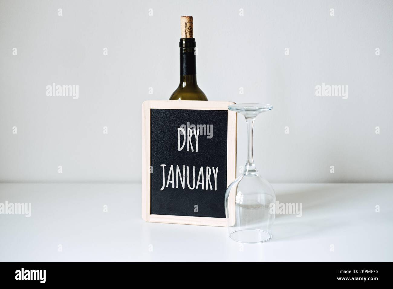 Gennaio secco. La sfida senza alcool, la campagna di salute che esorta la gente ad astenersi dall'alcool per il mese di gennaio. Bottiglia di vino, bicchiere e cartello con Foto Stock