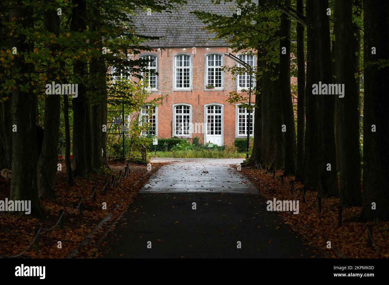 Ternat, Regione del Brabante Fiammingo, Belgio, 11 04 2022 - facciata del castello di Kruikenburg attraverso un vicolo di alberi Foto Stock