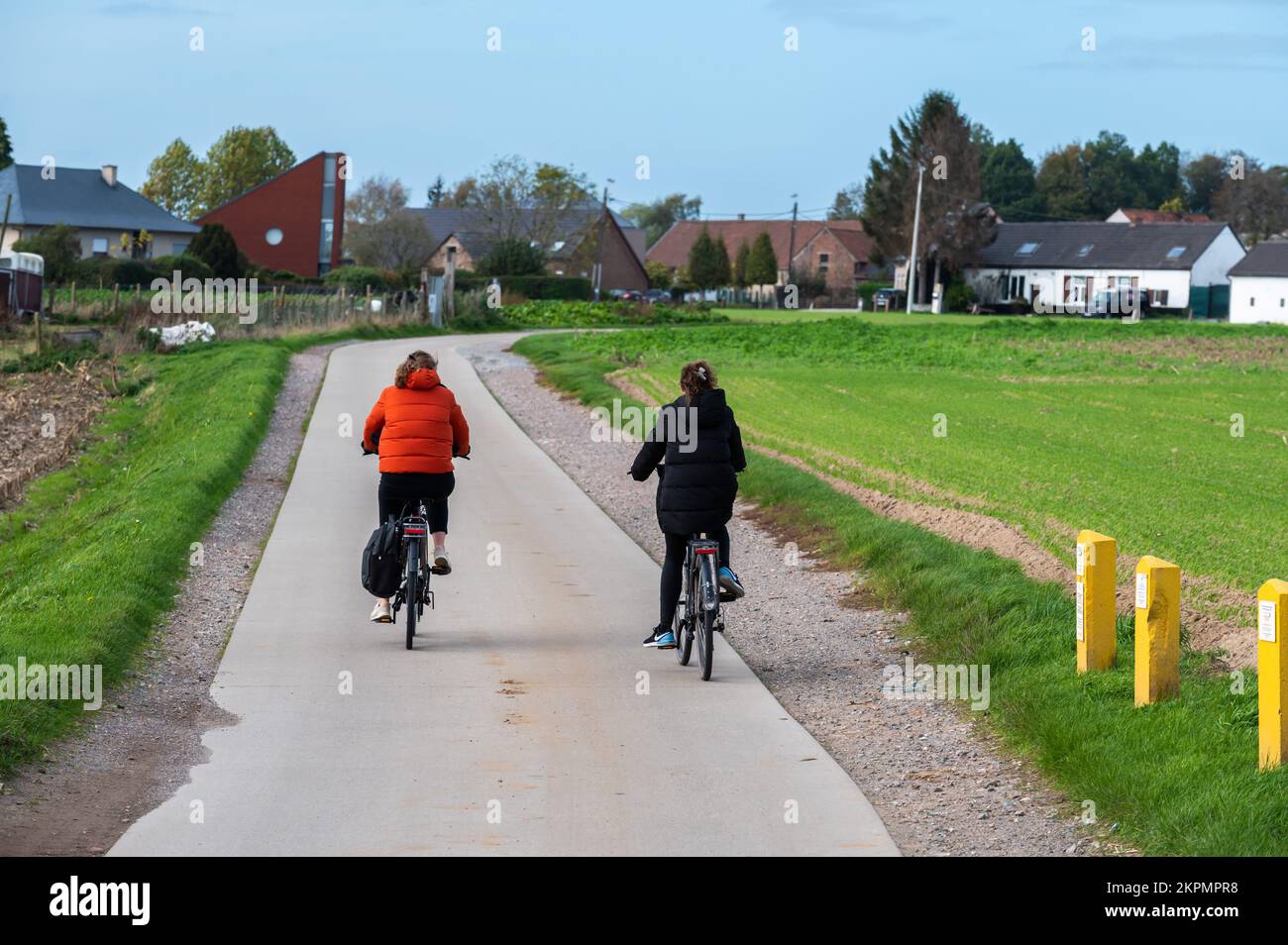 Asse, Regione del Brabante Fiammingo, Belgio - 10 20 2022 - Coppia guidando la bici attraverso i campi della campagna fiamminga Foto Stock