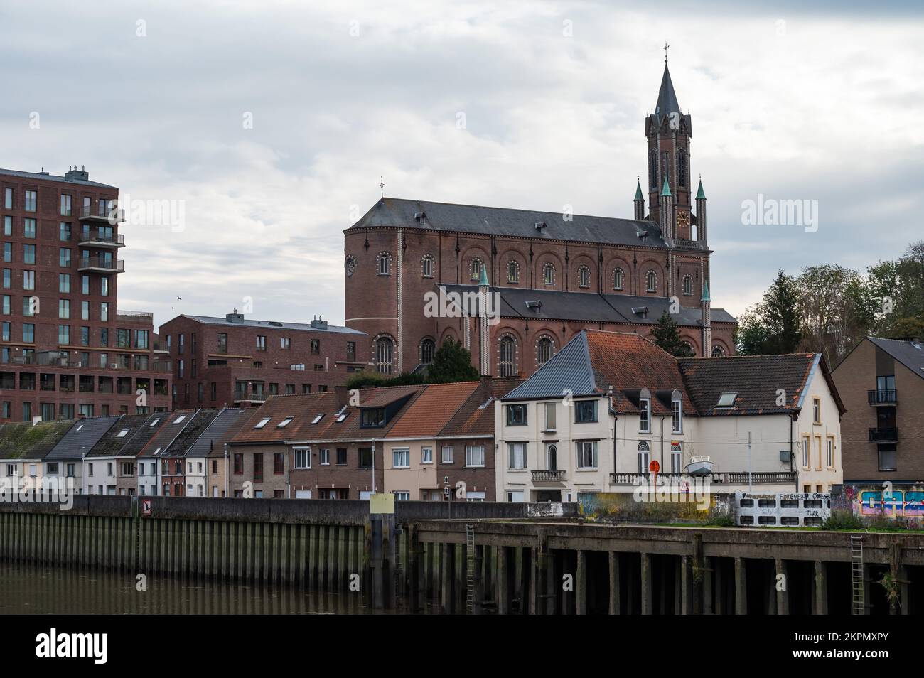WETTEREN, East Flemish Region, Belgio, 11 03 2022 - Vista sul villaggio, condomini e la chiesa dalle rive del fiume Scheldt Foto Stock
