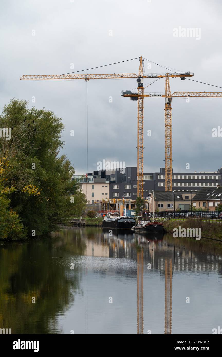 Aalst, Brabante Fiammingo, Belgio - 11 02 2022 - Gru industriali che si riflettono nelle acque del fiume Dender Foto Stock