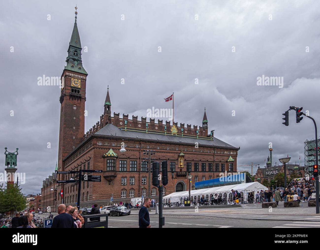 Copenaghen, Danimarca - 23 luglio 2022: Grande municipio in mattoni rossi con orologio e campanile domina dietro piazza Radhuspladsen molto trafficata sotto grigio cl Foto Stock