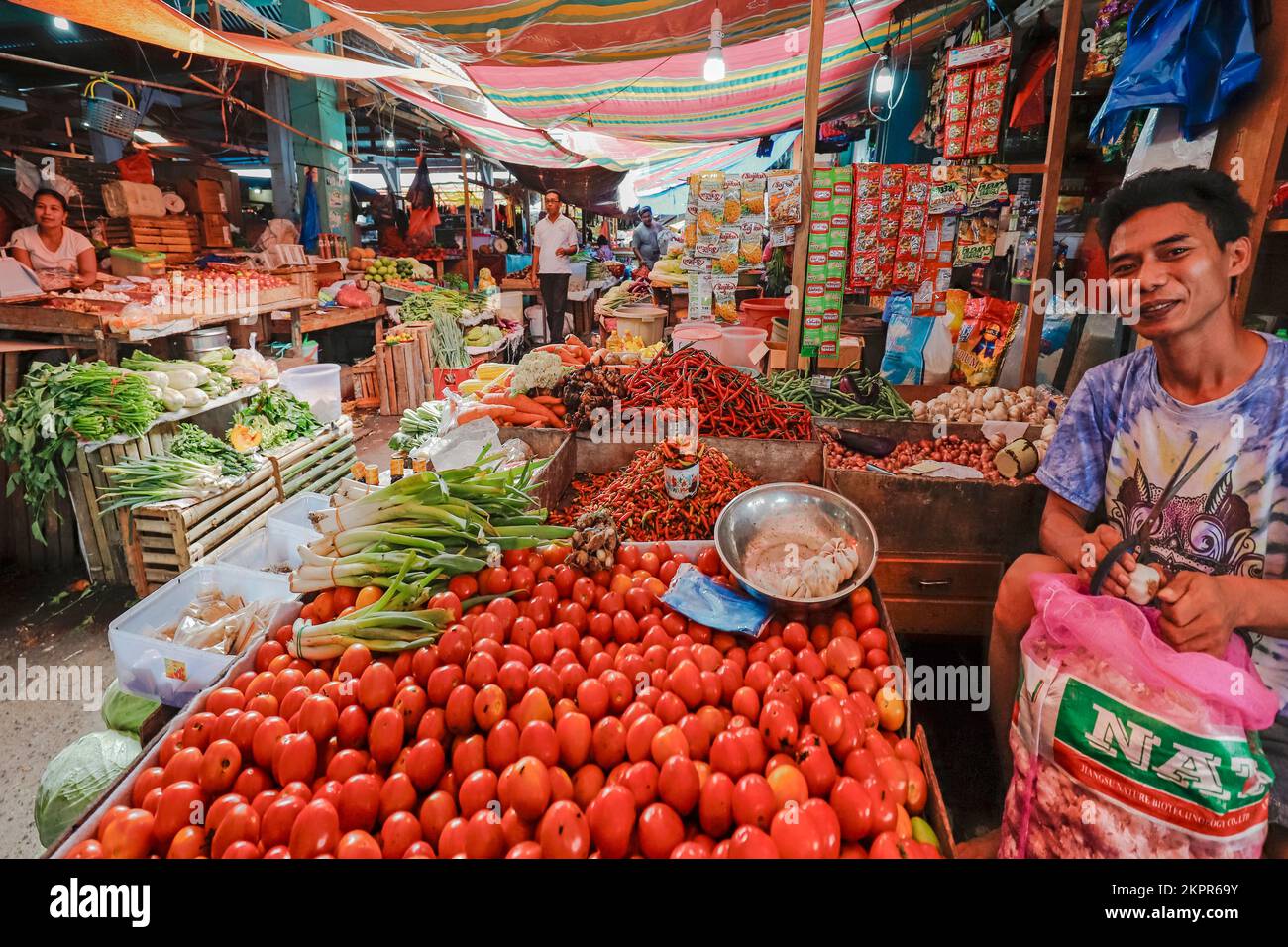 Stallholder mercato con peperoncino, cipolle, scalogni, pomodori, aglio nella capitale. Ulu, Isola di Siau, Arcipelago di Sangihe, Nth Sulawesi, Indonesia Foto Stock