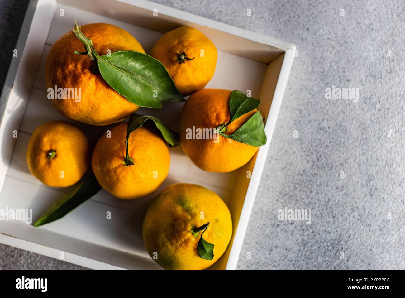 Vista dall'alto di una scatola di legno riempita di arance mature Foto Stock