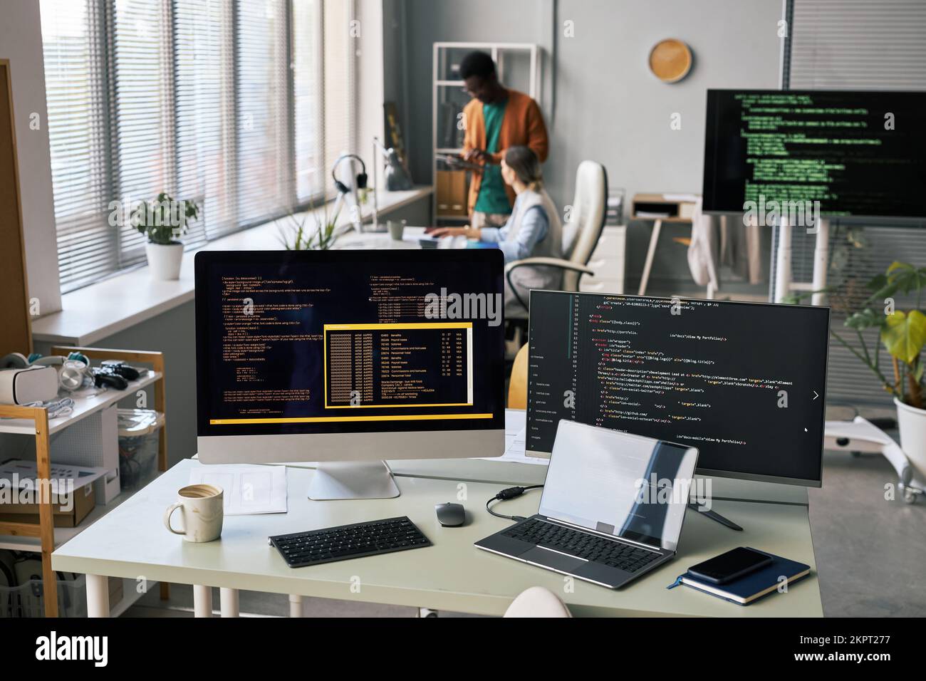 Computer e laptop con codice di programmazione sulla scrivania dello sviluppatore di software Foto Stock